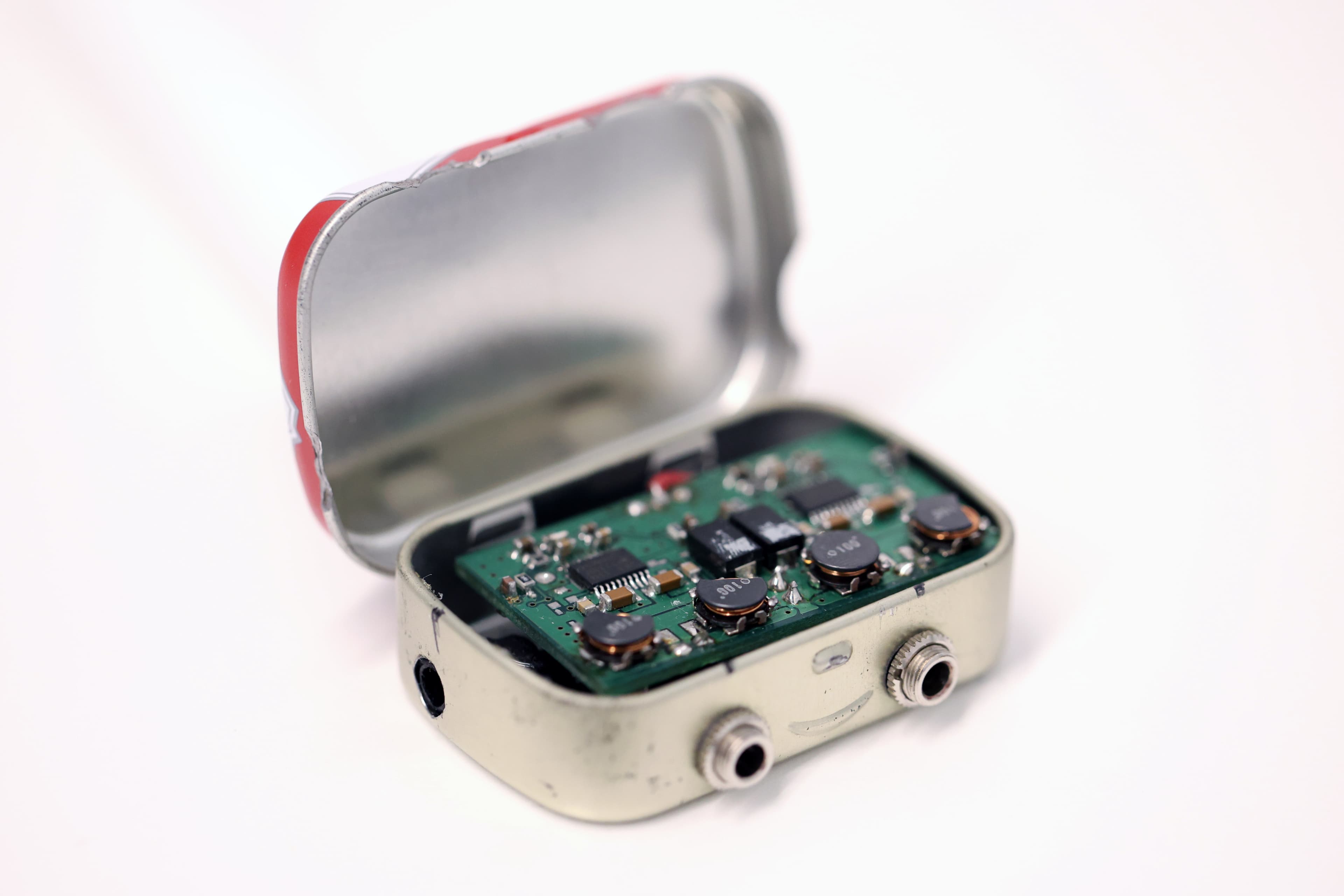 Opened Altoids tin containing the original amplifier electronics